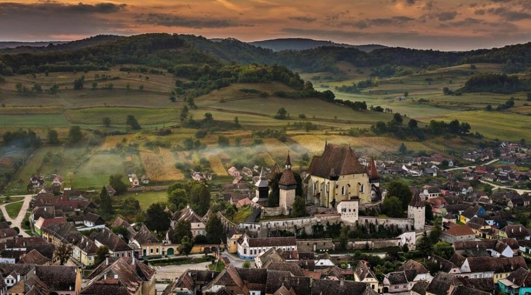 Panorama historycznej miejscowości w Transylwanii z warownym kościołem pośród wzgórz