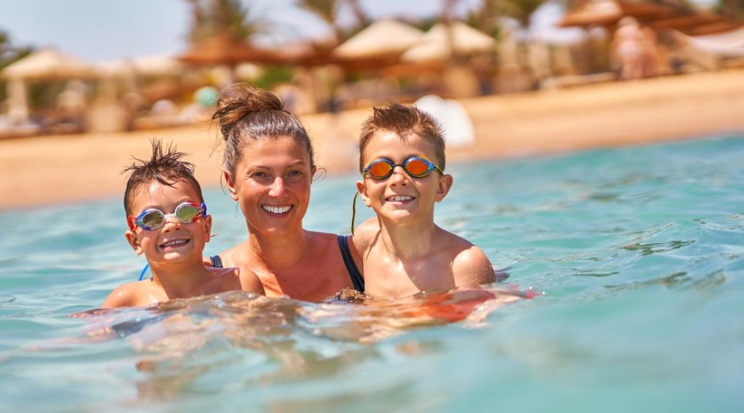 Rodzina z dziećmi kąpiąca się w basenie podczas zimowych wakacji w Egipcie.