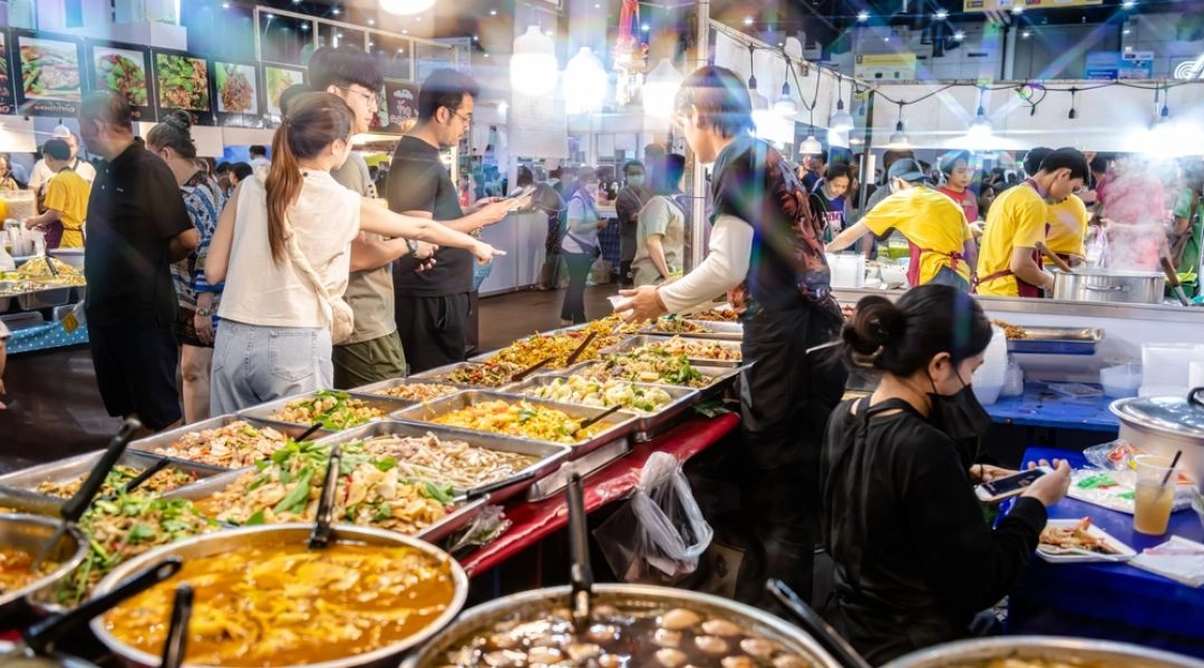 Bangkok street food nocny targ z tajskimi potrawami przygotowywanymi na stoiskach.