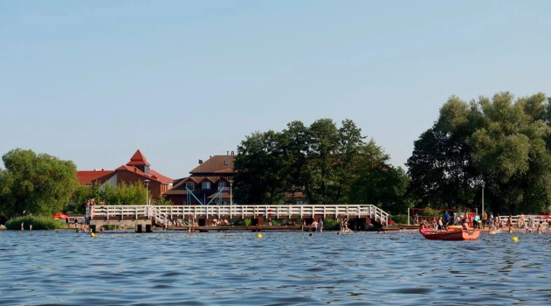 Kąpielisko na Dzikiej Plaży w Nieporęcie z pomostem, wydzieloną strefą kąpieli i osobami wypoczywającymi nad Zalewem Zegrzyńskim.