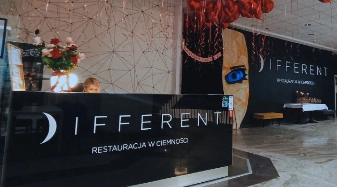 Wejście do restauracji Different w Warszawie z czerwonymi balonami i recepcją lokalu przy ul. Wilczej.