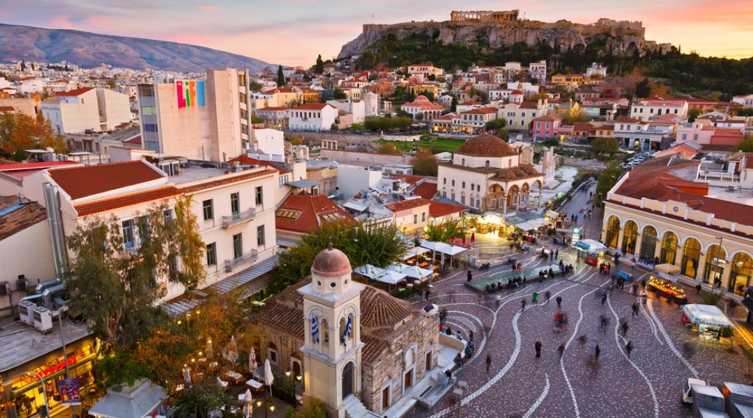Widok na plac Monastiraki w Atenach o zachodzie słońca, z Akropolem górującym nad miastem.