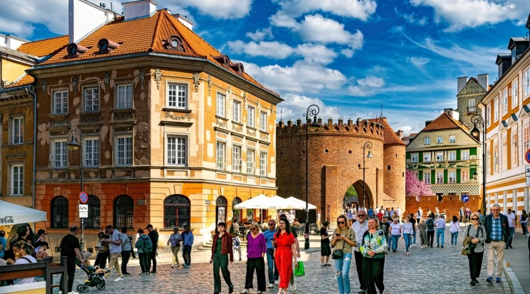 Kładka pieszo-rowerowa nad Wisłą w Warszawie z dużą liczbą spacerujących osób.