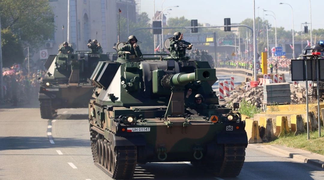 Samobieżne armatohaubice jadą ulicą podczas defilady wojskowej w Warszawie