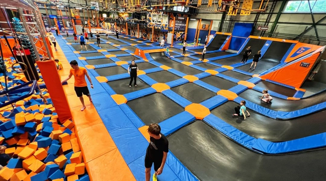 Park trampolin w Warszawie z dużą halą wypełnioną trampolinami, rampami i strefą do skakania podczas ferii zimowych.