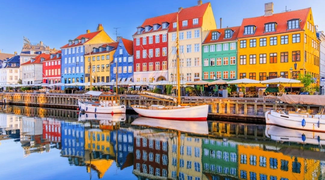 Kolorowe kamienice i łodzie zacumowane przy nabrzeżu Nyhavn w Kopenhadze.