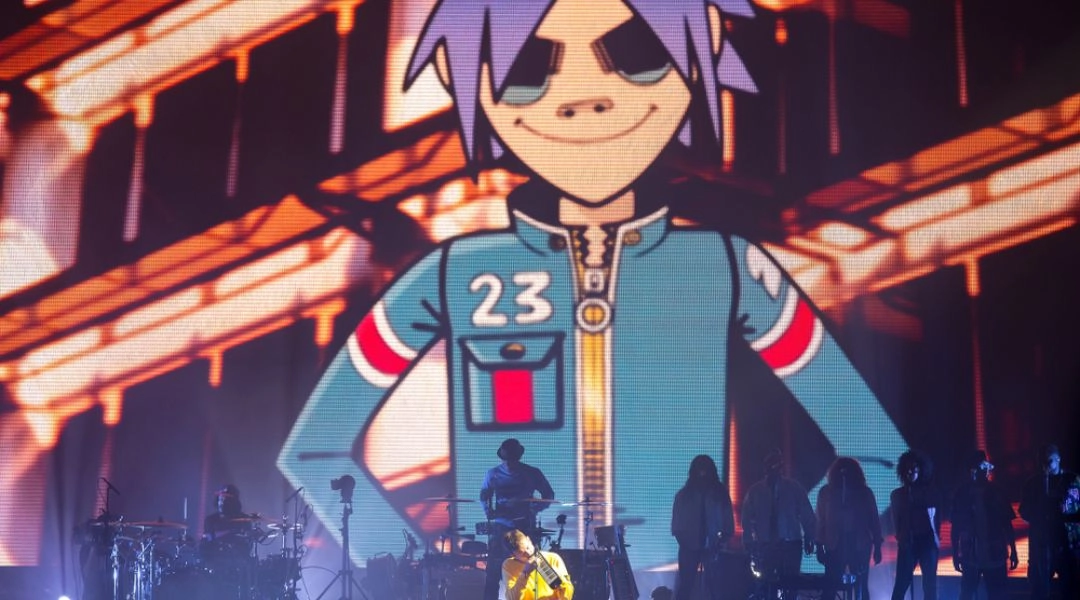 Koncert Gorillaz z animowaną postacią wyświetlaną na ogromnym ekranie za sceną.