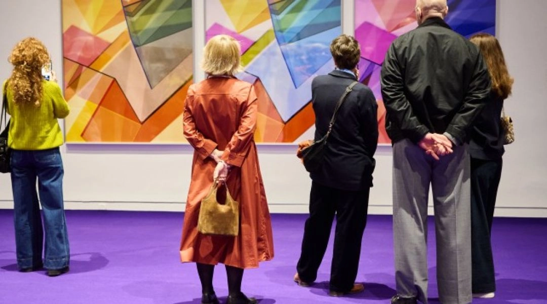 Zwiedzający stoją przed kolorowymi pracami Barbary Kasten na wystawie w Zachęcie w Warszawie.