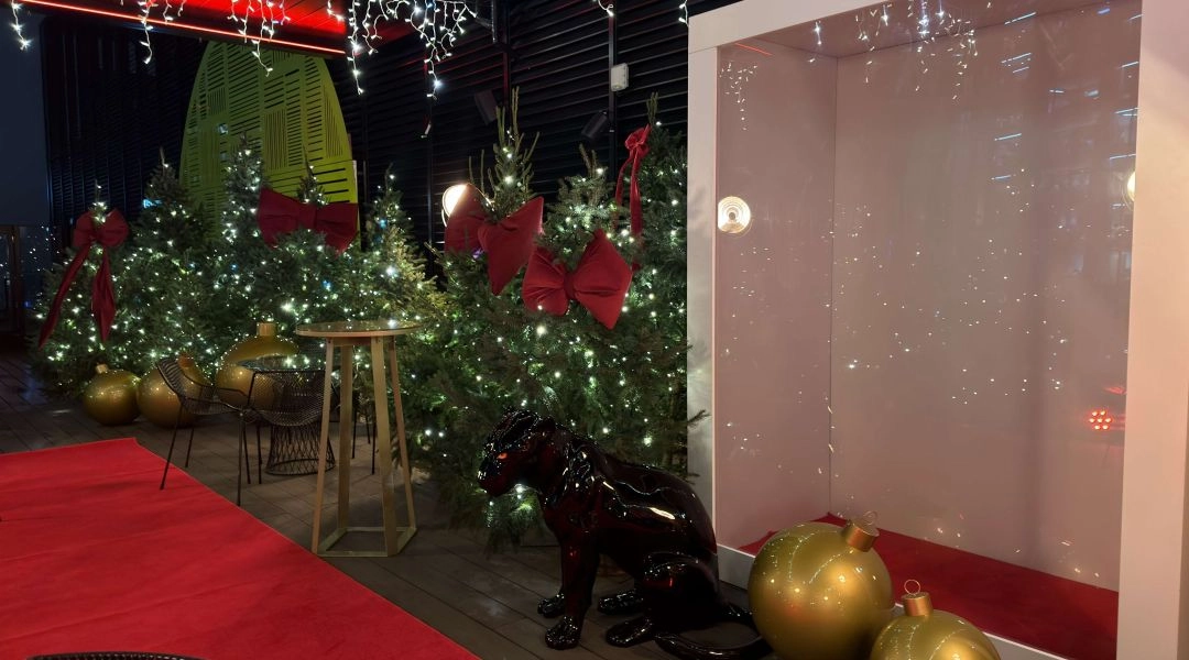 Zimowa aranżacja Winter WOWderland z choinkami, dużymi ozdobami świątecznymi i dekoracyjną strefą na dachu hotelu.