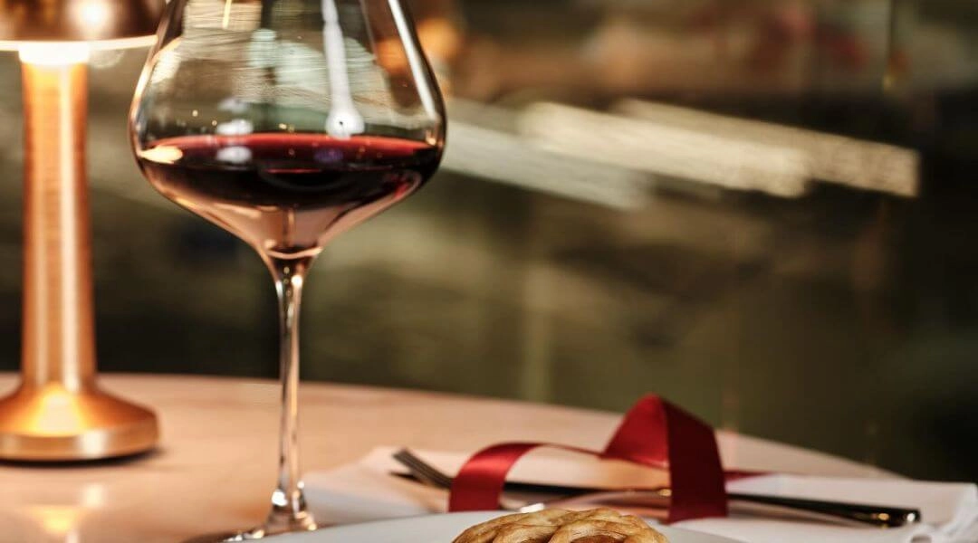 Romantyczna kolacja walentynkowa w Warszawie, deser i kieliszek czerwonego wina.