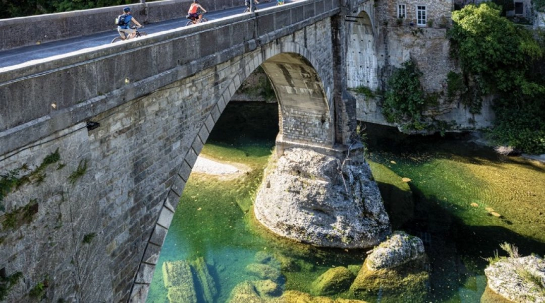 Most Diabła w Cividale del Friuli z turkusową rzeką Natisone i zabudową starego miasta.