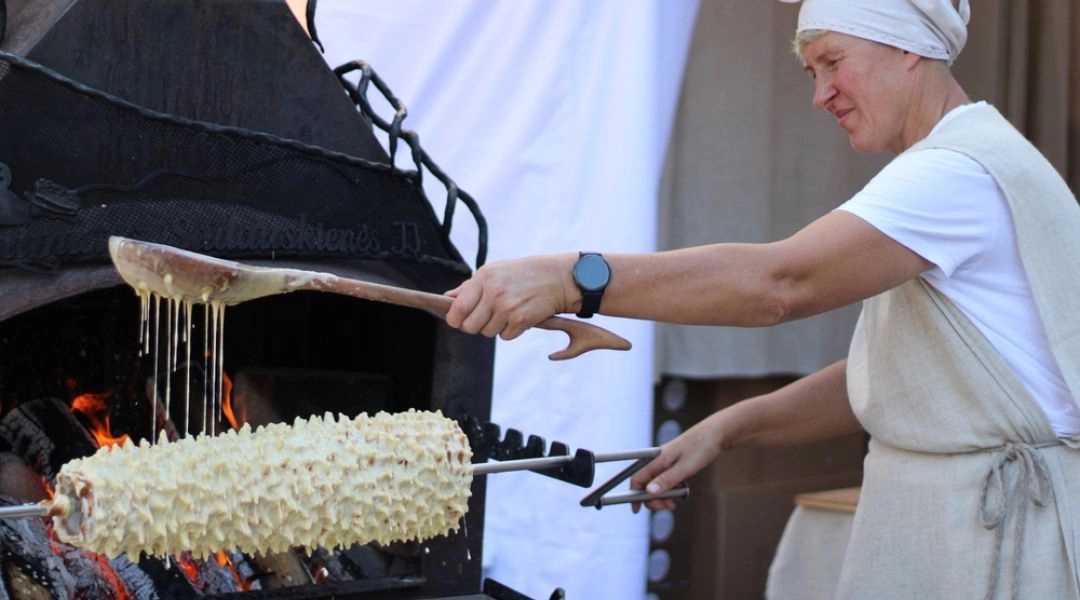 Pokaz tradycyjnego wypieku sękacza nad otwartym ogniem podczas festiwalu kulinarnego.