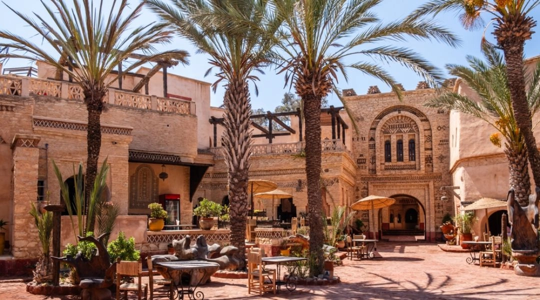 ziedziniec riadu w Agadirze w Maroku z palmami i tradyjną zabudową.