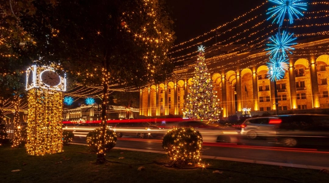 Rustaveli Avenue w Tbilisi nocą, z choinką, dekoracjami świątecznymi i iluminowanymi budynkami.