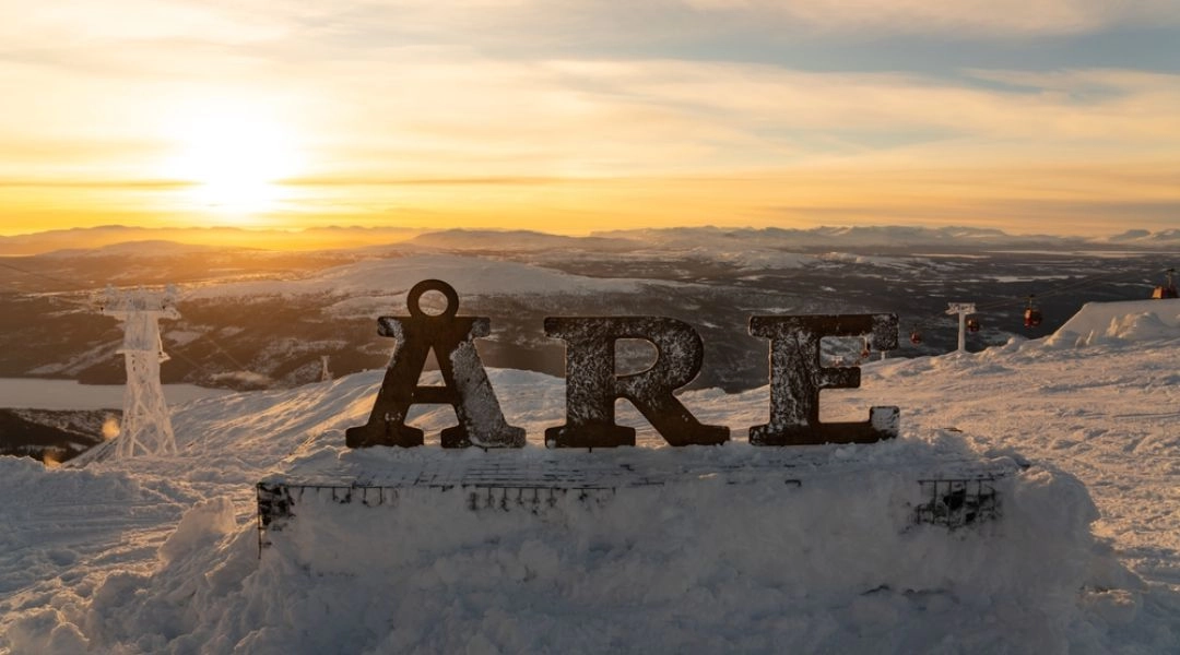 Panorama ośrodka narciarskiego Åre w Szwecji o zachodzie słońca z napisem ÅRE na pierwszym planie