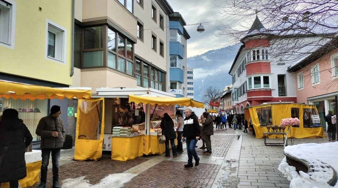 Stragany i spacerujący mieszkańcy na ulicy w centrum Lienz w Tyrolu Wschodnim.