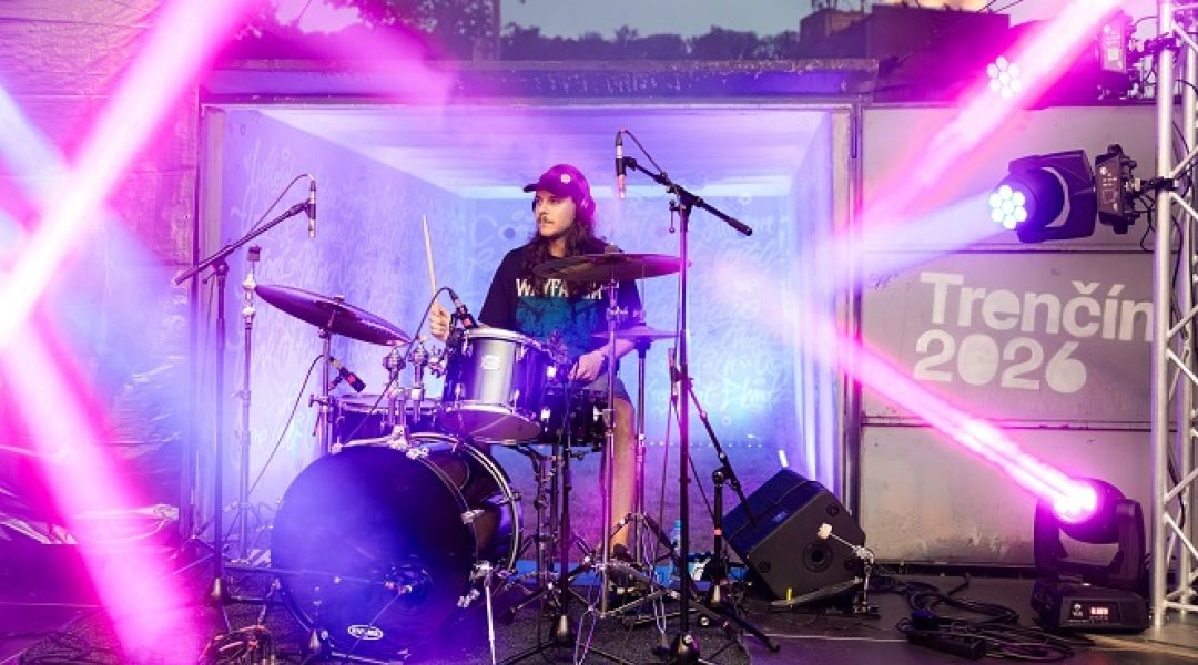 Koncert zespołu rockowego na scenie plenerowej Trenczyn 2026 z oświetleniem scenicznym.
