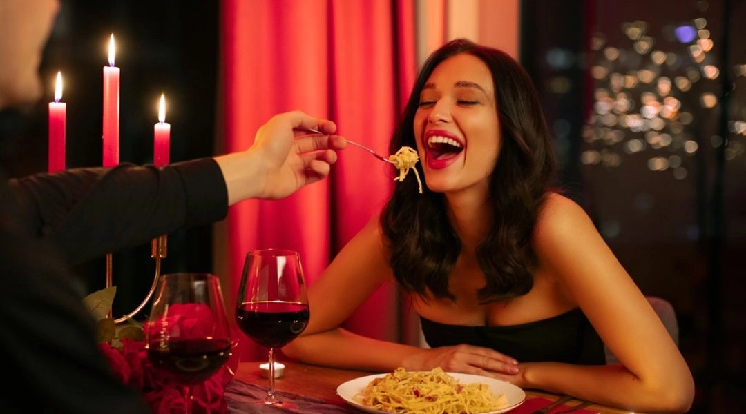 Romantyczna kolacja walentynkowa przy świecach, para w restauracji, makaron i wino