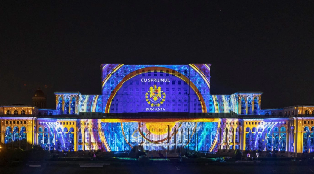 Kolorowy mapping świetlny na fasadzie Pałacu Parlamentu w Bukareszcie nocą