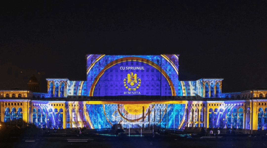 Kolorowy mapping świetlny na fasadzie Pałacu Parlamentu w Bukareszcie nocą