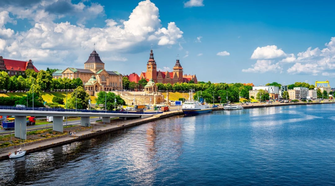 Panorama Szczecina nad Odrą z Wałami Chrobrego i zabudową miasta w słoneczny dzień.