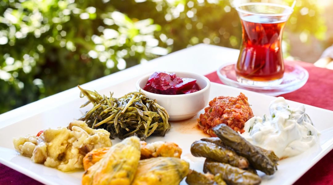 Tureckie meze z warzywami i herbata w szklance w kształcie tulipana.