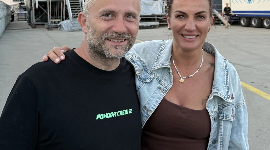 Uśmiechnięty mężczyzna w czarnej koszulce z napisem Pohoda Crew - Michal Kaščák i kobieta Autorka w jeansowej kurtce pozują razem na zapleczu festiwalowej sceny.