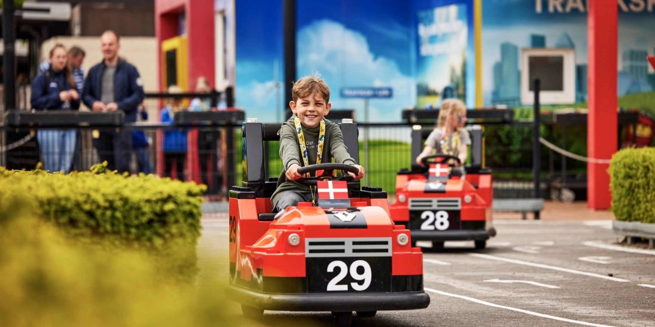 Dziecko prowadzi mały czerwony samochód na torze w Legolandzie w Billund
