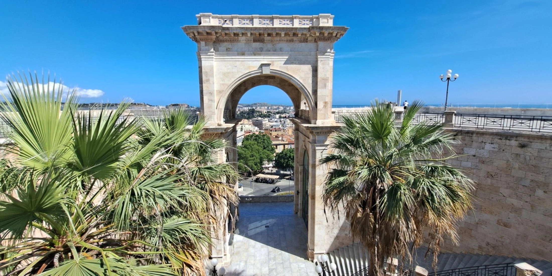 Dawna kopalnia Porto Flavia Monumentalny łuk Bastione di Saint Remy w Cagliari otoczony palmami i kamiennymi schodami. w stromym klifie nad turkusowym morzem na Sardynii.