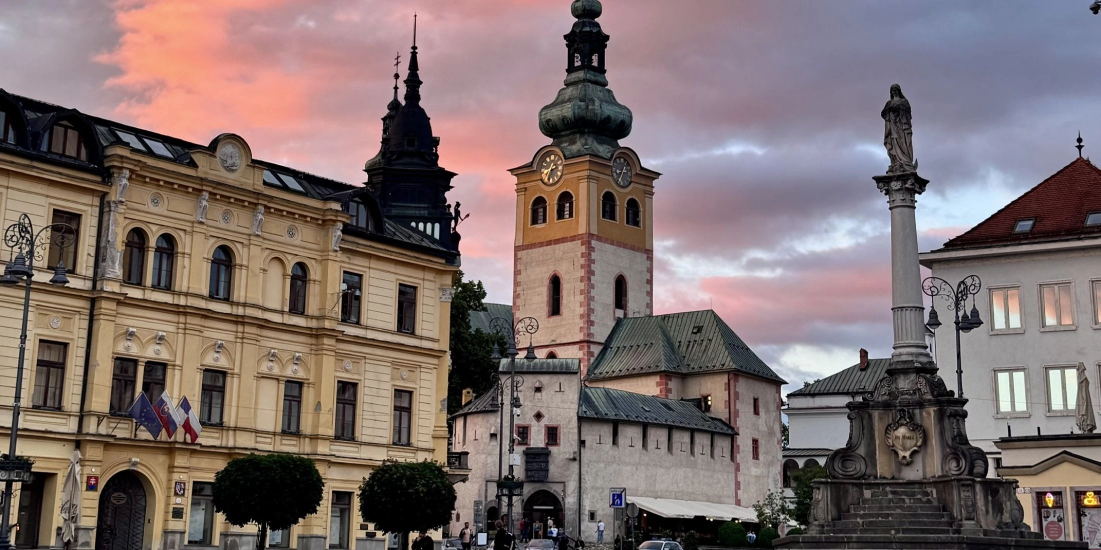 Zabytkowa wieża i kompleks zamku miejskiego przy placu SNP w Bańskiej Bystrzycy o zachodzie słońca.
