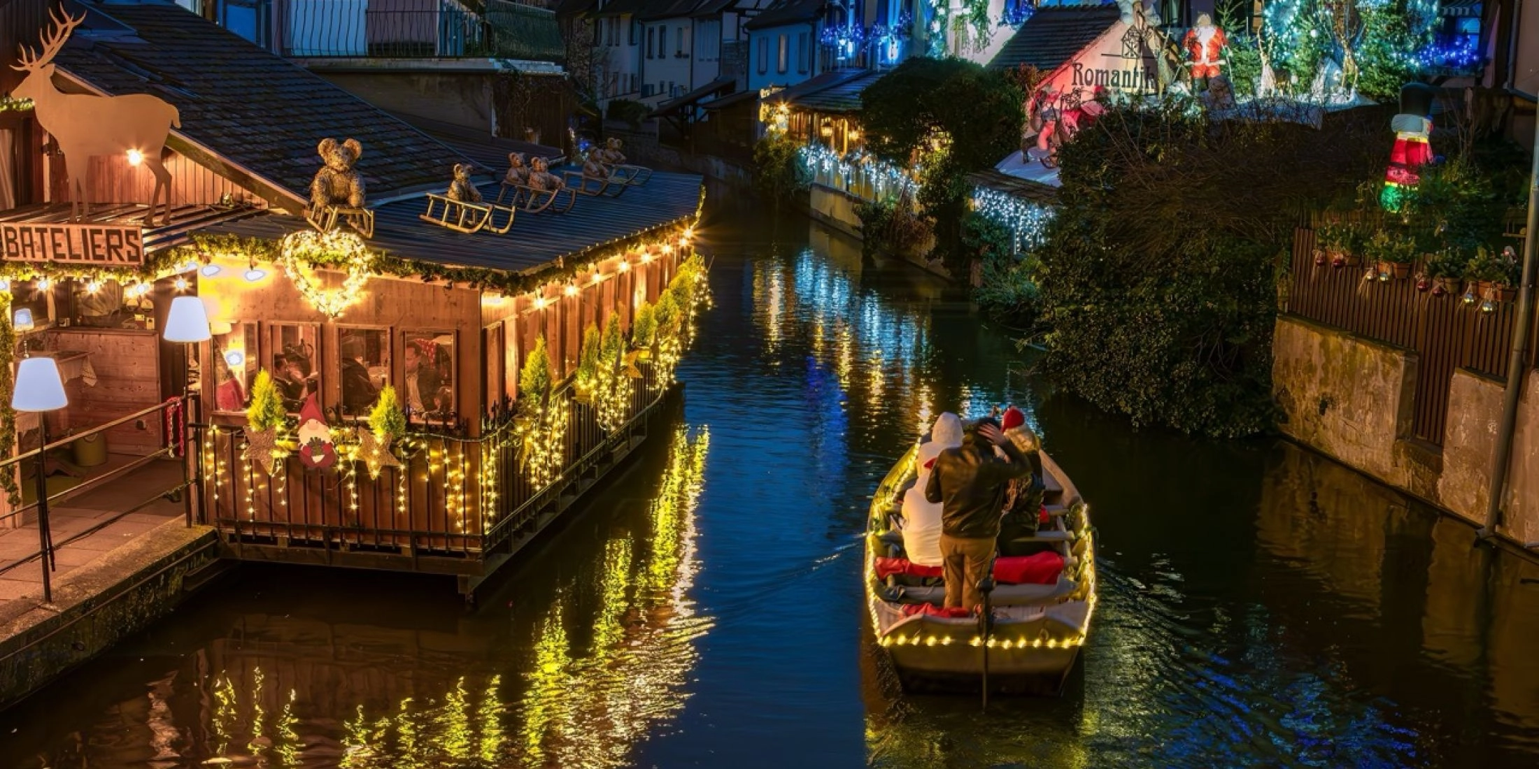 Colmar w czasie świąt, zabudowa nad kanałem Petite Venise z delikatnymi iluminacjami bożonarodzeniowymi.