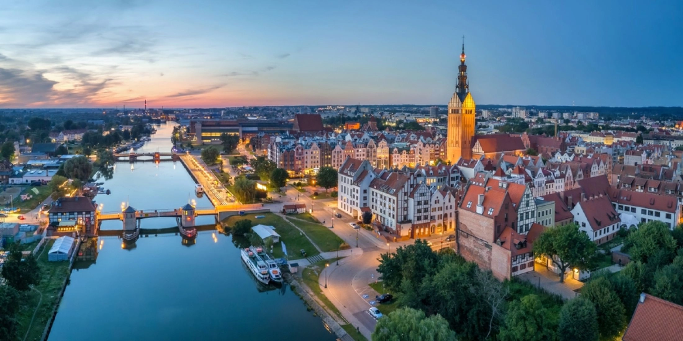 Panorama Elbląga o zmierzchu z rzeką Elbląg, katedrą św. Mikołaja i zabudową Starego Miasta.