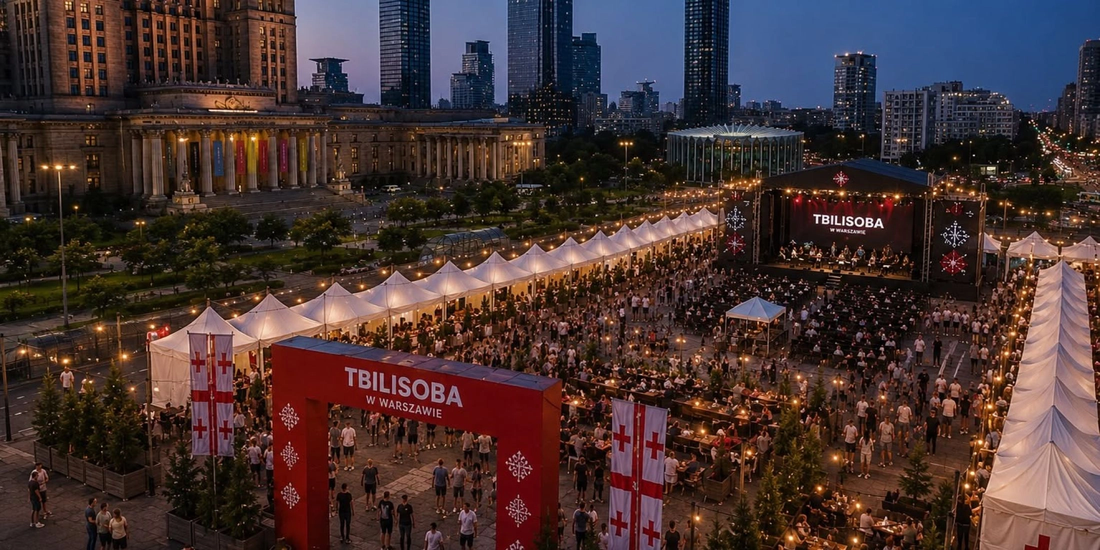 Teren festiwalu Tbilisoba w centrum Warszawy, scena, stoiska i publiczność, w tle Pałac Kultury i Nauki
