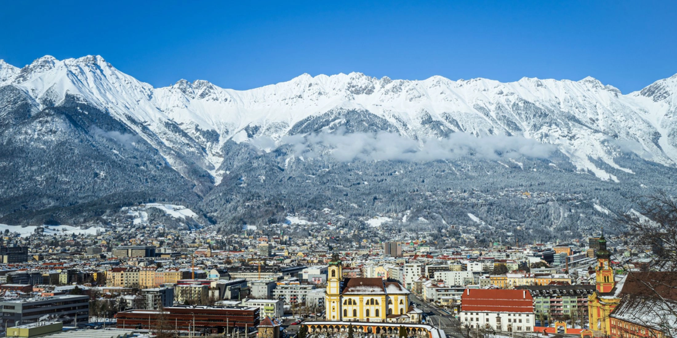 Panorama Innsbrucka zimą z widokiem na miasto i Alpy.