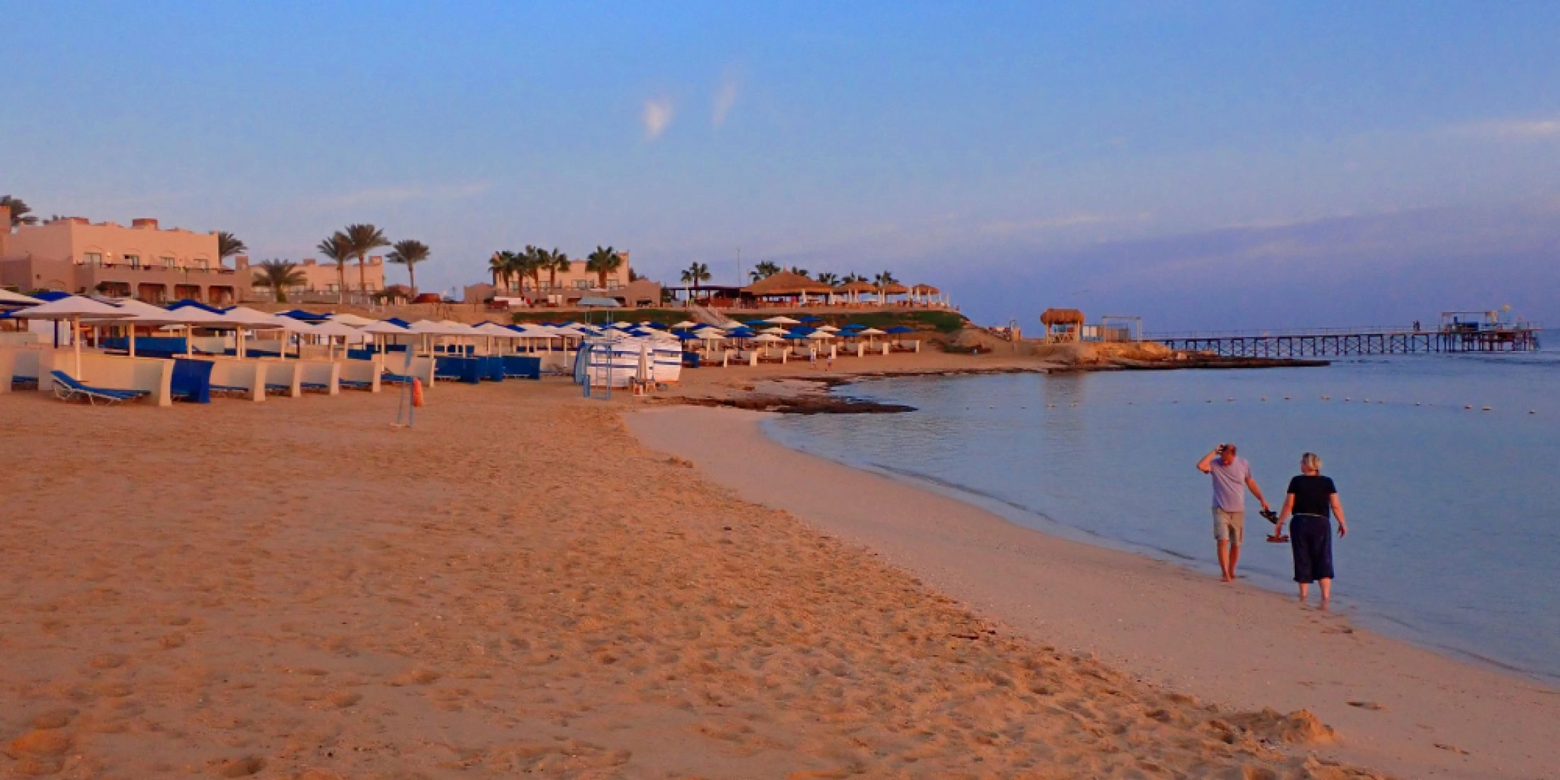Piaszczysta plaża w Marsa Alam nad Morzem Czerwonym, parasole plażowe i spokojna linia brzegowa