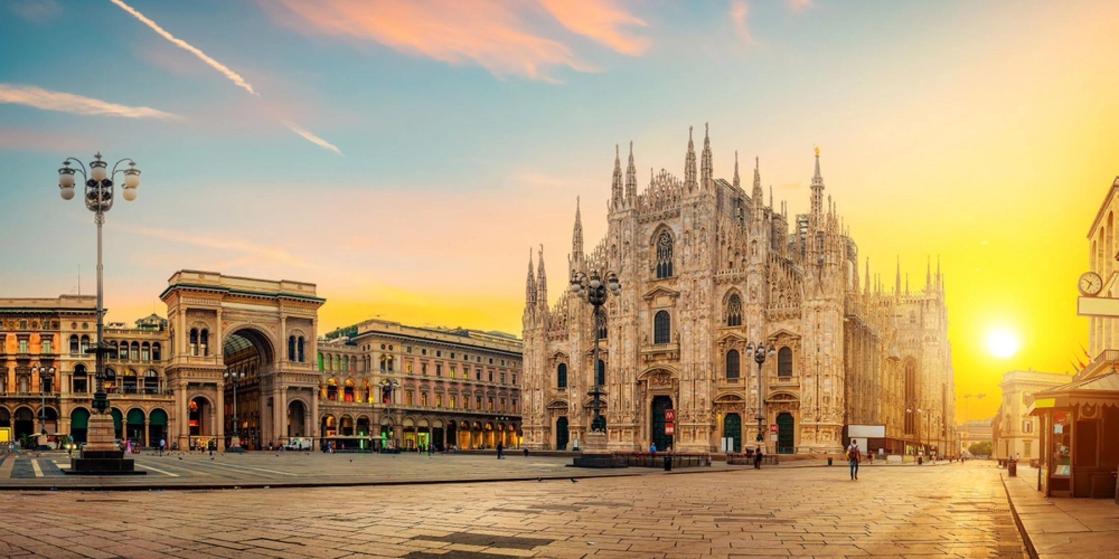 Katedra Duomo w Mediolanie i Galeria Vittorio Emanuele II w świetle zachodzącego słońca, pusty plac Piazza del Duomo.