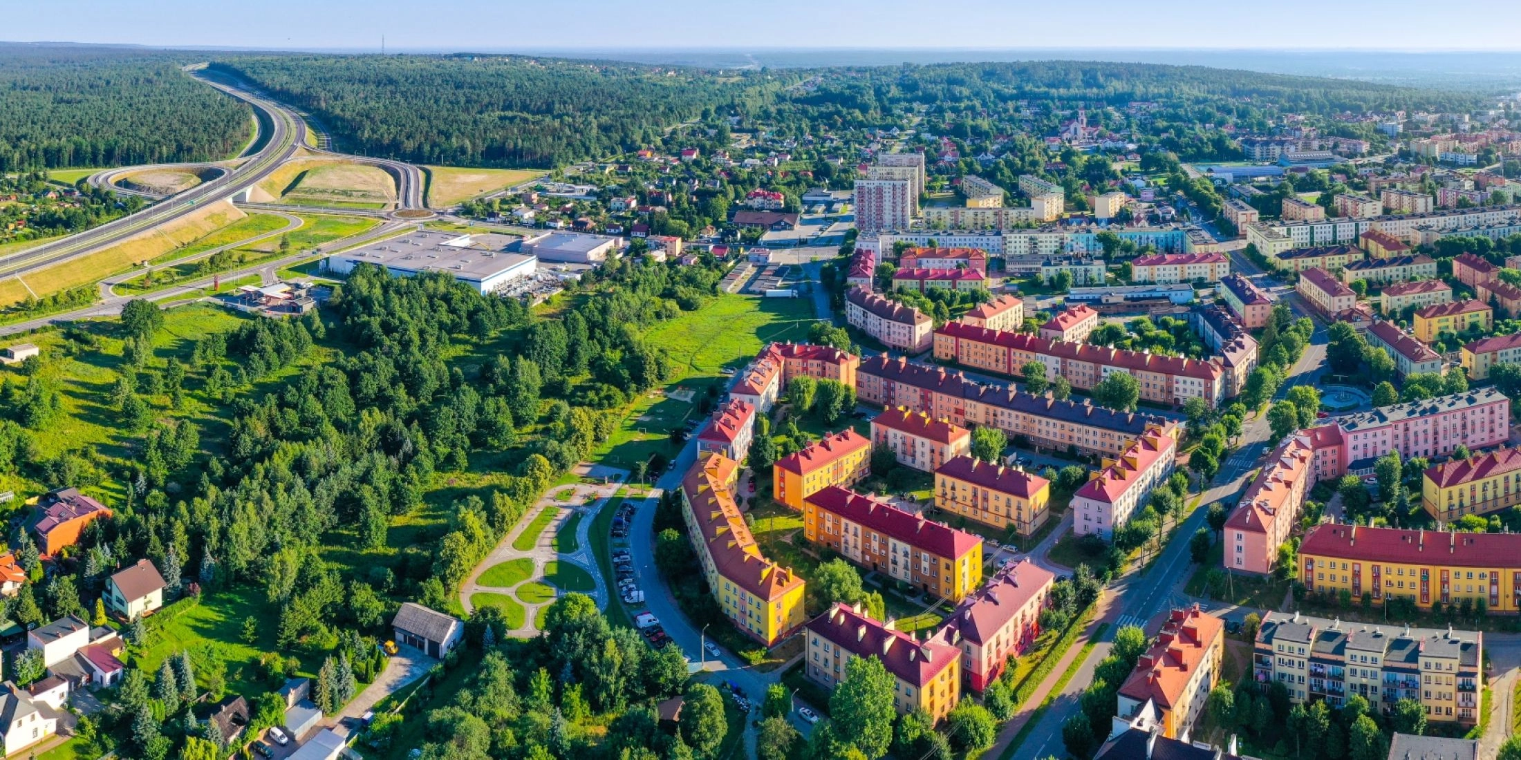 Panorama Skarżyska-Kamiennej z lotu ptaka, z osiedlami mieszkaniowymi, lasami i trasą S7.