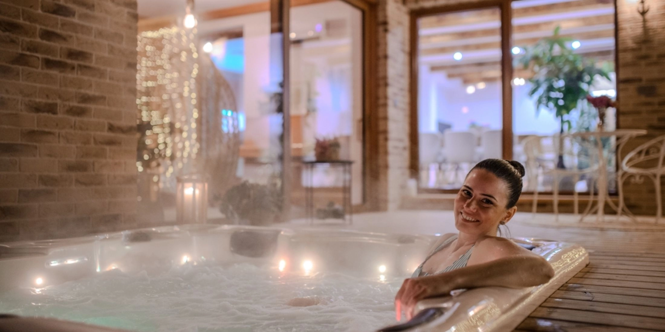 Kobieta relaksująca się w jacuzzi w hotelowym spa w zimowej atmosferze.