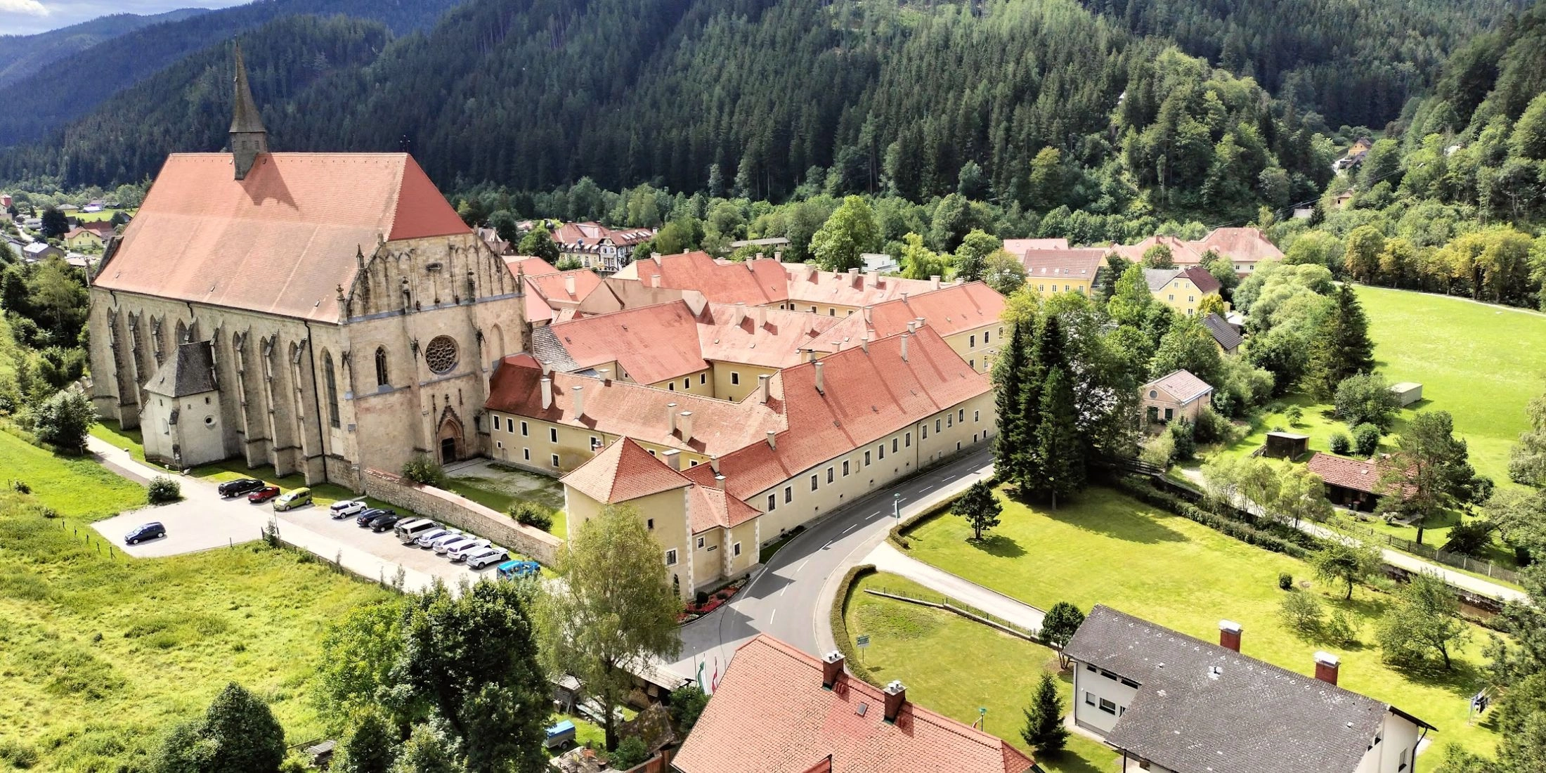 Skaliste wzgórze z krzyżem i tradycyjna zabudowa w Neuberg an der Mürz