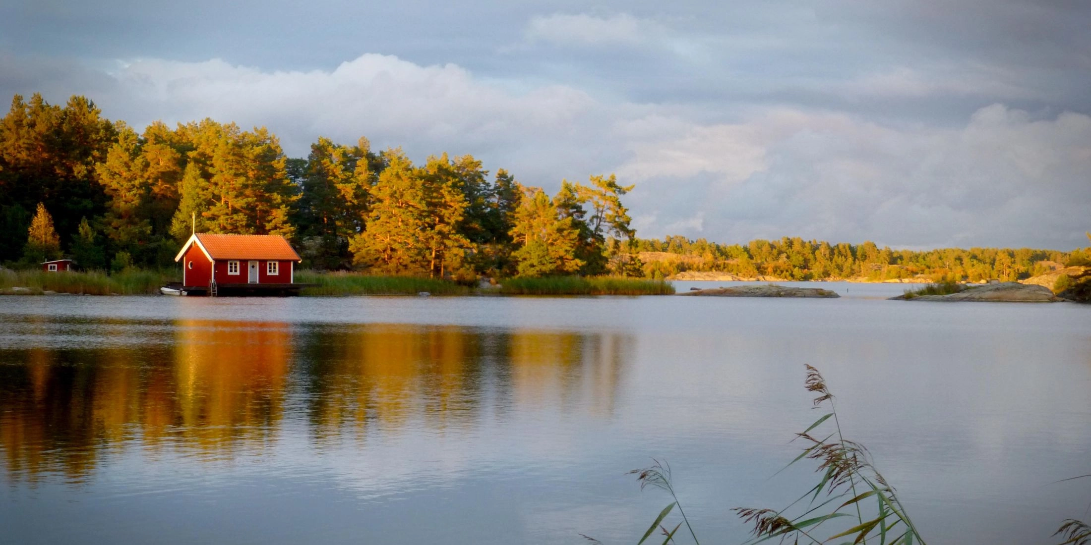 Czerwony drewniany domek nad wodą na jednej z wysp szwedzkiego archipelagu.
