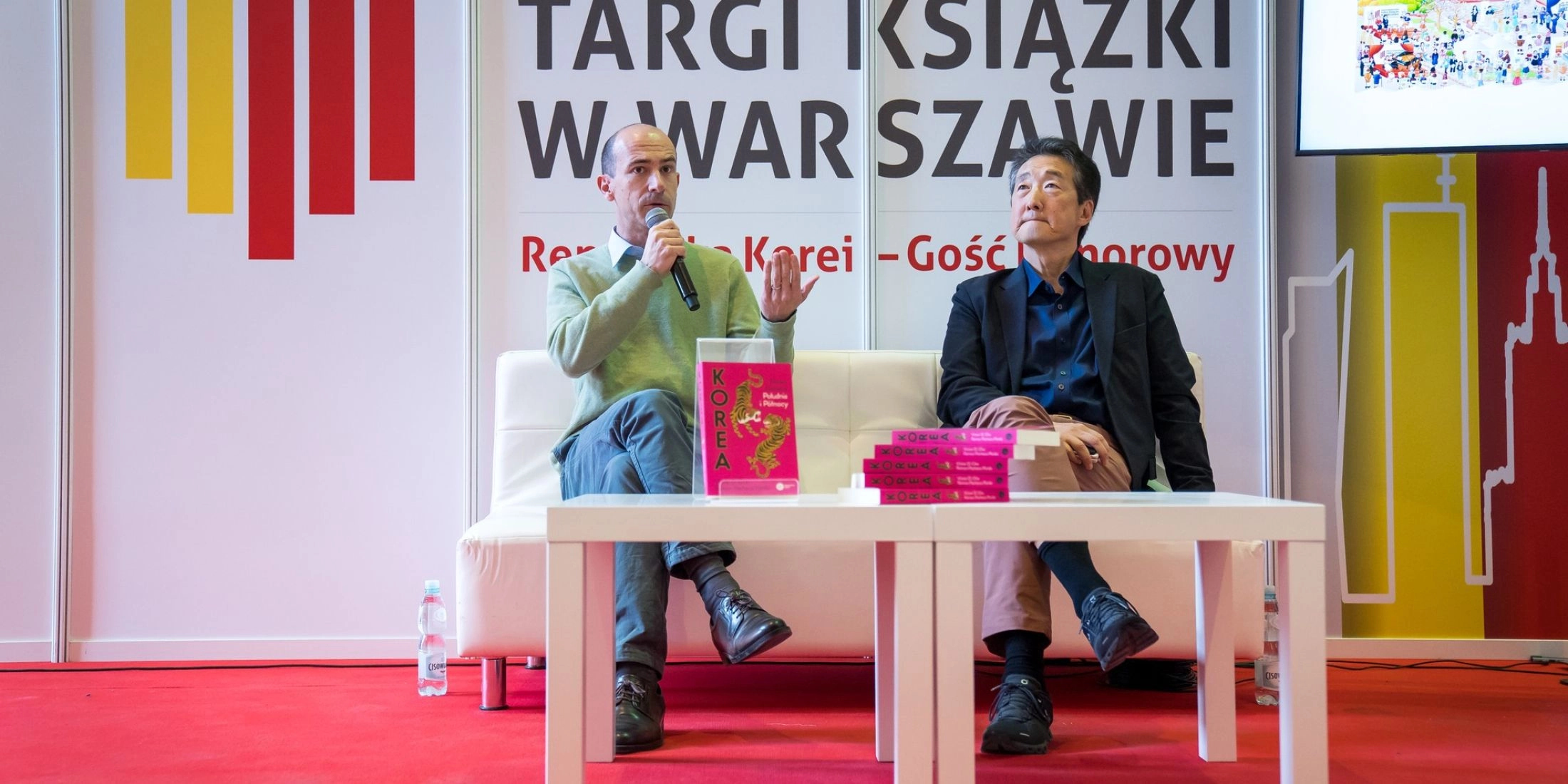Panel dyskusyjny podczas Międzynarodowych Targów Książki w Warszawie, autorzy rozmawiają na scenie przed publicznością.