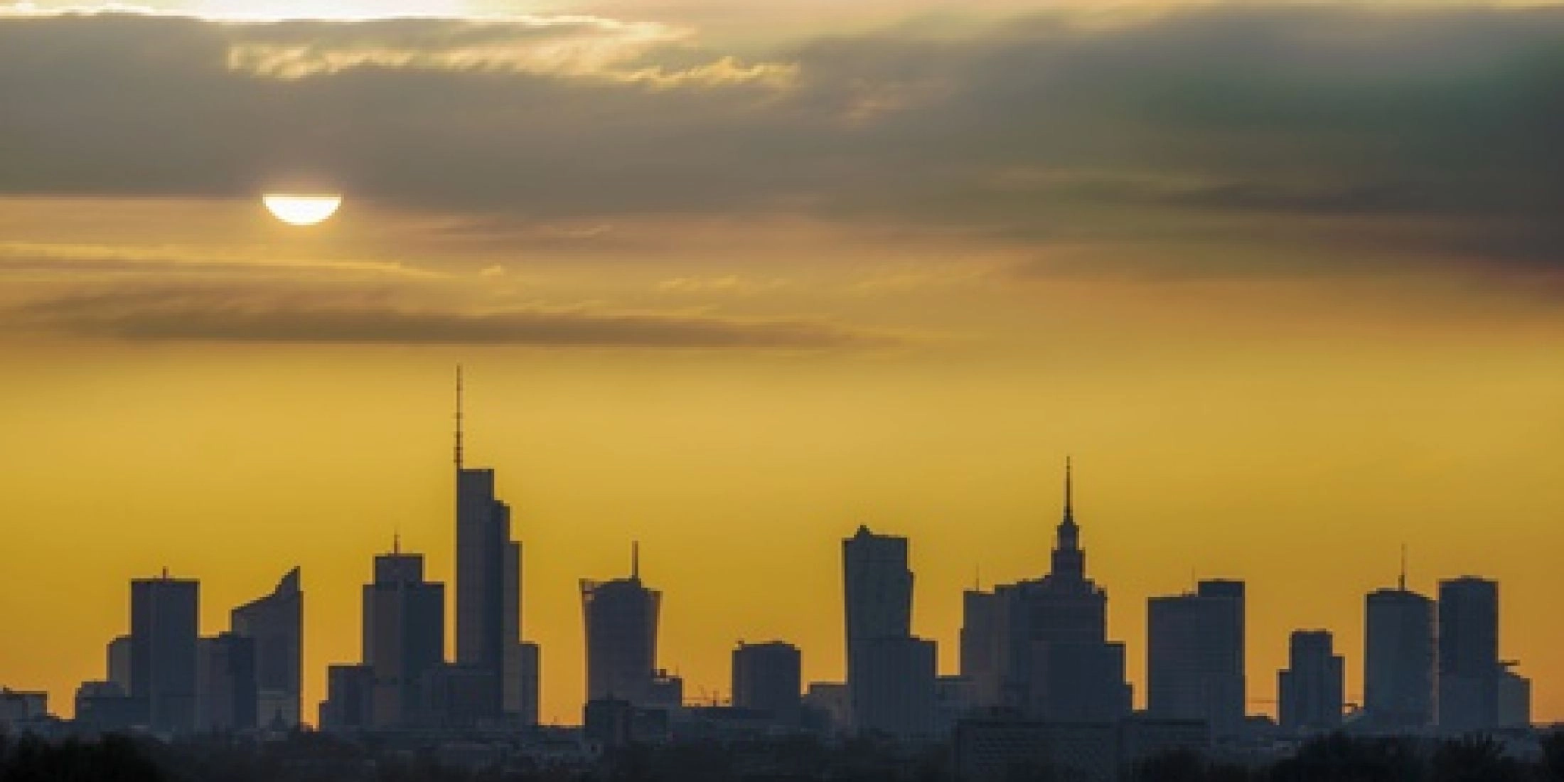 Panorama Warszawy o zachodzie słońca z widokiem na centrum miasta.