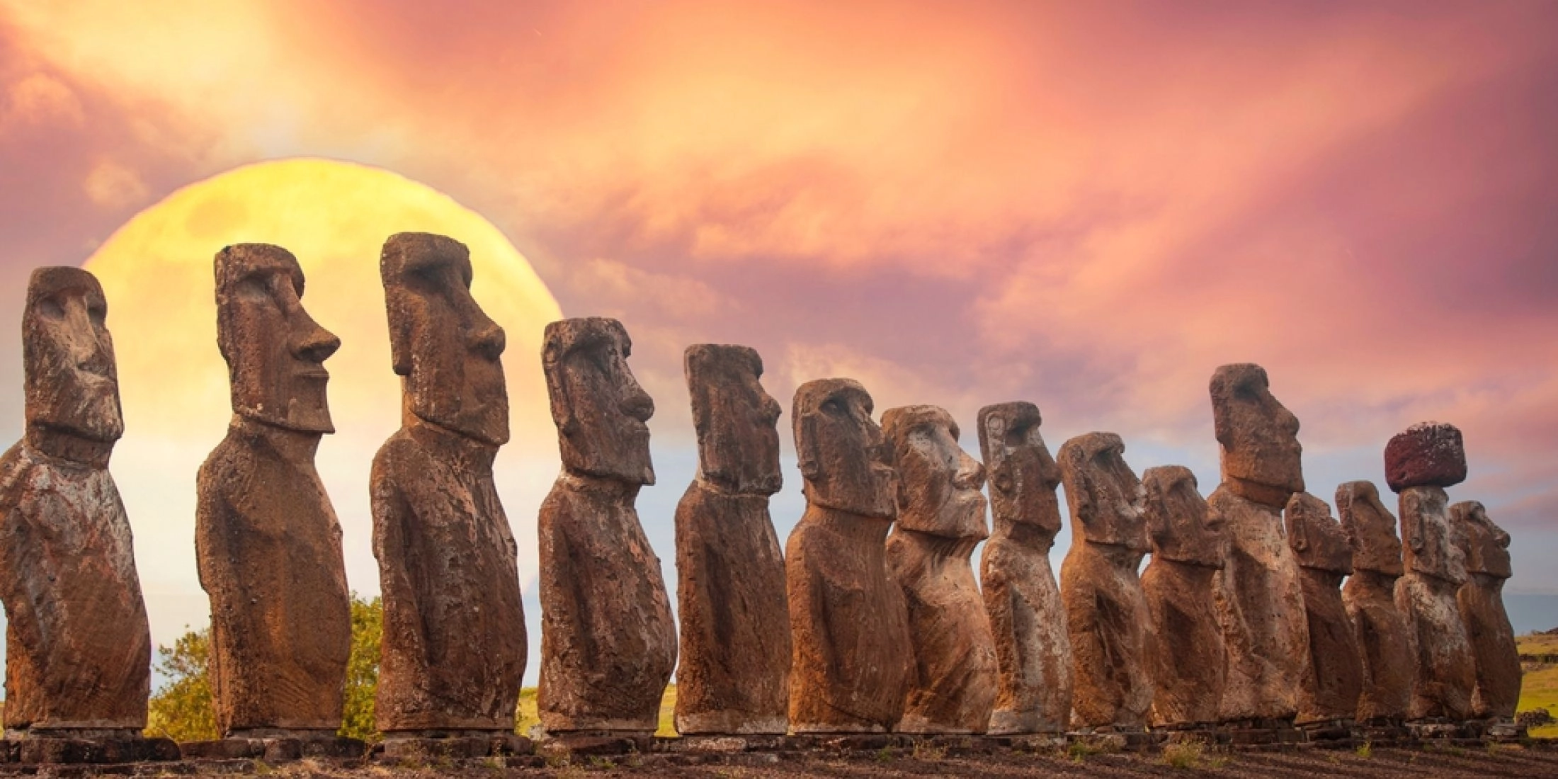 Ahu Tongariki na Wyspie Wielkanocnej z rzędem moai o zachodzie słońca