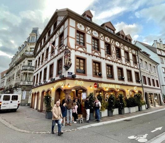 Kamienica z muru pruskiego w centrum Miluzy, narożny budynek z kawiarnią na parterze i charakterystyczną alzacką architekturą.