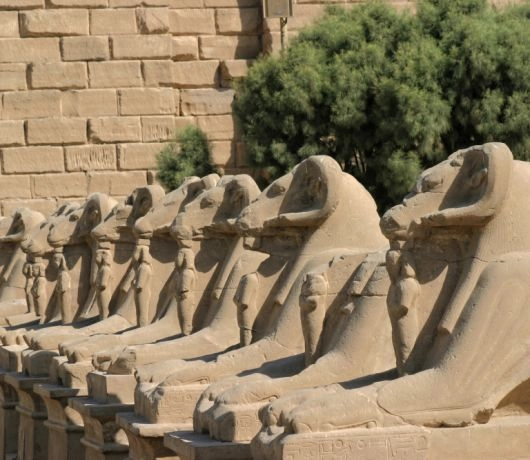 Aleja sfinksów w Karnaku w Luksorze, kamienne rzeźby lwów z ludzką głową ustawione w jednym rzędzie