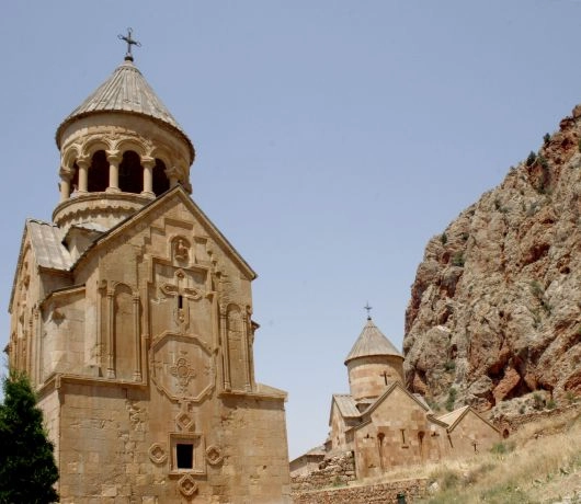 Klasztor Geghard w Armenii, zabudowania klasztorne na tle czerwonych skał