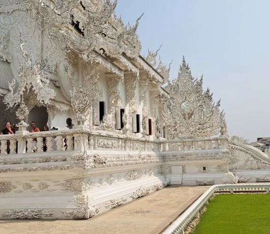 Detale elewacji Wat Rong Khun w Chiang Rai, bogato zdobione białe rzeźby i balustrady Białej Świątyni, Tajlandia.