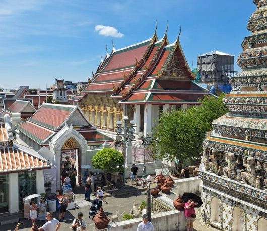 Wat Arun w Bangkoku – widok na świątynne dachy i misternie zdobione wieże pokryte porcelaną.