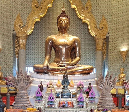 Posąg Złotego Buddy w Wat Traimit w Bangkoku, wykonany z litego złota i otoczony bogato zdobionym ołtarzem.