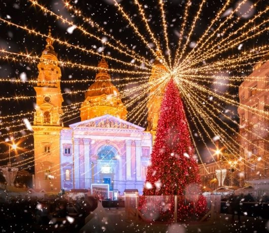 Plac przed Bazyliką św. Stefana w Budapeszcie z choinką i świetlną kopułą, nocne śnieżne kadry jarmarku.